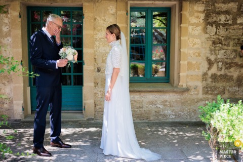 At a reception in Hérault, Occitanie, the photographer captures the bride's father becoming visibly moved upon seeing her, expertly preserving a raw, heartfelt moment of emotion and familial love.