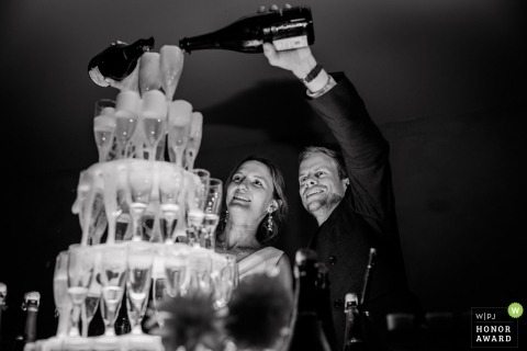 A spectacular champagne fountain flows as the centerpiece for the newlyweds' dessert course, creating a luxurious and celebratory atmosphere at their reception venue in the Hérault region of France.