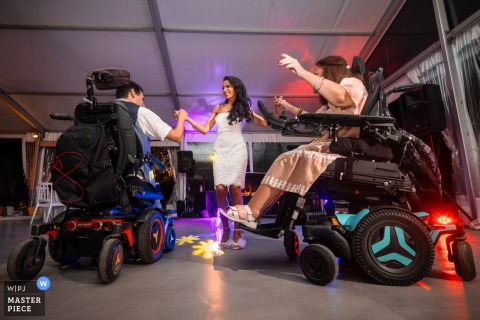 In Montpellier, the photographer captures the bride dancing joyfully with her friends in a wheelchair, skillfully highlighting inclusive celebration and genuine happiness with remarkable sensitivity and timing.