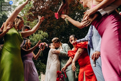 Newlyweds Share Kiss Before Witnesses In Dramatic Low Angle Shot At Château Les Hauts At Château les Hauts, the photographer captures the newlyweds sharing a kiss before their witnesses in a dramatic low angle shot, expertly highlighting romance.