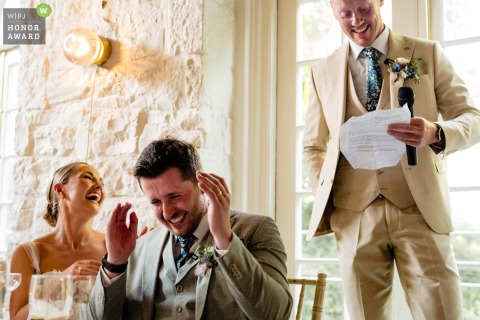 The best man delivers an engaging and heartfelt speech to the seated guests during a refined wedding breakfast celebration at the picturesque Cliff at Lyons estate in Ireland.