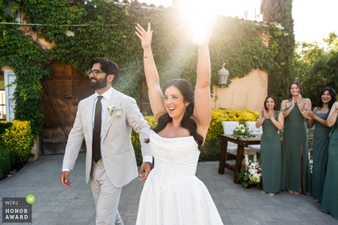 The bride and groom make a spectacular grand entrance into their reception at Milagro Winery in Ramona, California, greeted by the enthusiastic cheers of their gathered friends and family.