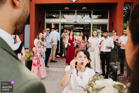 Joyful Bubble Exit at Saint-Priest City Hall with Bride, Groom, and Bridesmaid Bubble-filled wedding exit at the city hall of Saint-Priest, France with the happy couple and their bridesmaid.