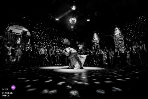 At Alte Schlossfabrik in Solingen, the photographer captures the bride and groom’s first dance in a wide black-and-white shot, beautifully freezing their dramatic dip and kiss with masterful moment awareness.