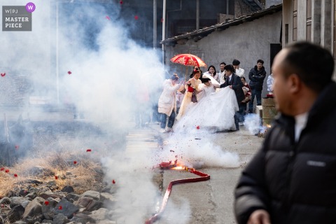 Chinese bride at her Fujian home falls amidst a smoky scene after being frightened by firecrackers.