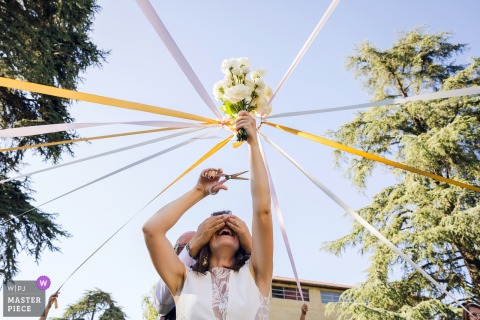 Reception in Lyon, Rhône. Single women play the ribbon game; one woman with the last uncut ribbon wins the bouquet.