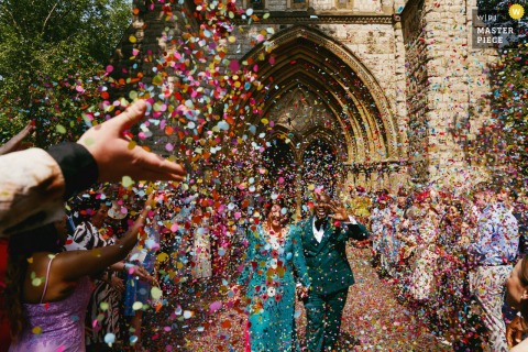 London's St. John of Jerusalem Church wedding, couple exits into rainbow confetti.
