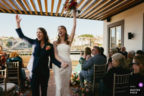 At Mira Mira in Porto, Portugal, the photographer captures the couple’s jubilant rooftop ceremony exit, expertly freezing their radiant joy and triumphant celebration in a striking, moment-driven image.