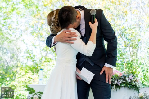 An emotional groom finds comfort in a raw, silent embrace within the bride’s arms during a deeply moving and personal moment at the Hotel HO Jaén in Jaén, Spain.