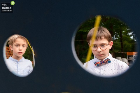 Young Children Focus Intently On A Traditional Wooden Tabletop Game During Festive Celebrations In France Two young children focus intently on a traditional wooden tabletop game, enjoying a quiet moment of play during the wedding festivities held at Le Bois des Anglais in France.