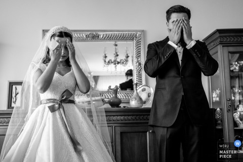 A black-and-white image captures an emotional moment as the bride and groom pray together before leaving the groom’s Başakşehir home, showcasing the photographer’s remarkable ability to preserve raw, heartfelt emotion.