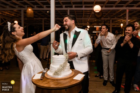 A WPJA-winning photo at Goga Beach Club in Istanbul captures a playful, smiling bride and groom during their cake cutting, demonstrating the photographer’s skill in seizing joyful, candid moments.