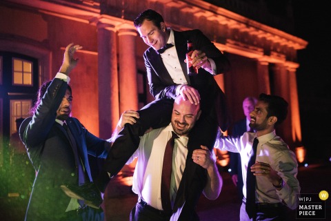 At a Lisbon reception, the groom rides on his friends’ shoulders during a dance floor celebration. The photographer’s timing captures the candid joy and camaraderie of this memorable party moment.