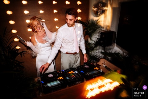 At The Seahorse, Brighton, the bride and groom DJ their own wedding. The photographer’s technical mastery with slow shutter blur captures dynamic movement and the vibrant atmosphere in low light.