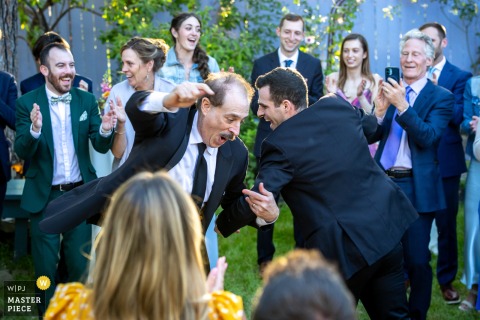 At Lavender Inn, Ojai, the groom and his father dance the Hora on the grass, encircled by friends and family. The photographer’s creative composition captures the joyous tradition and togetherness of the moment.