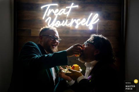 At Tapestry House by Wedgewood Weddings, a couple hand-feeds yellow cake to each other. The photographer’s technical precision highlights the playful intimacy and joyful celebration of this wedding tradition.