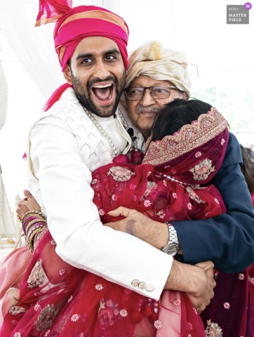Greystone at Piedmont Park, Atlanta Wedding: Couple Hugs Groom’s Grandfather After Fire Ceremony At Greystone at Piedmont Park in Atlanta, the bride and groom hug the groom’s grandfather after the Hindu fire ceremony.