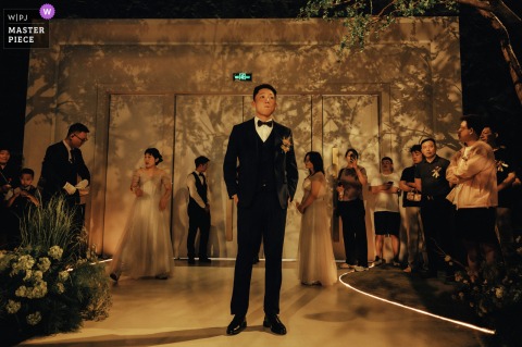 In Kaifeng, Henan, the groom waits patiently for the wedding ceremony to begin, anticipation and excitement evident on his face.