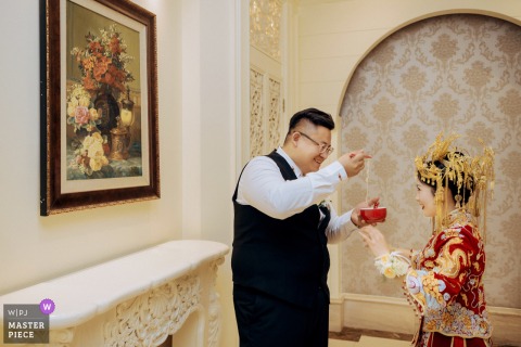 At a hotel in Kaifeng, Henan, the groom playfully feeds noodles to the bride as they follow the traditional custom symbolizing long-lasting happiness after the wedding ceremony.
