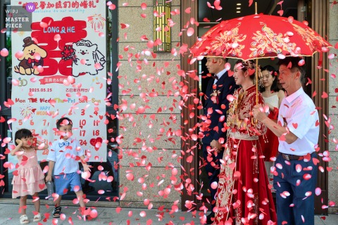 At home in Zhanjiang, Guangdong, the bride steps out of her childhood home as her father stands beside her, gently shielding her with an umbrella in a touching pre-wedding tradition.