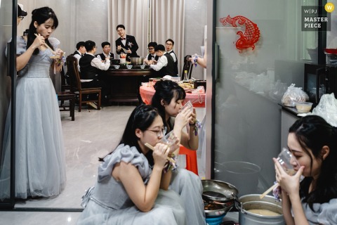 At home in Zhanjiang, Guangdong, the groom follows tradition by arriving early to pick up the bride, sharing breakfast with his groomsmen before the wedding festivities begin.