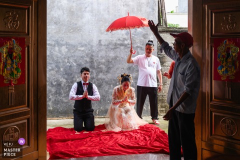 At home in Zhanjiang, Guangdong, the newlyweds honor Chinese tradition by offering tea to the groom’s parents, expressing deep respect and gratitude during the wedding celebration.