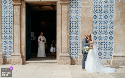 In Maia, Porto, outside a historic Old World church, the groom sees the bride for the first time, he is filled with awe and emotion.