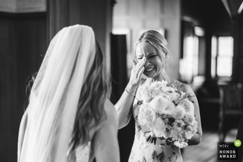 During a heartfelt moment at a ceremony in Ohio, the bride’s sister beams with happiness as she sees her sibling in her beautiful wedding dress.