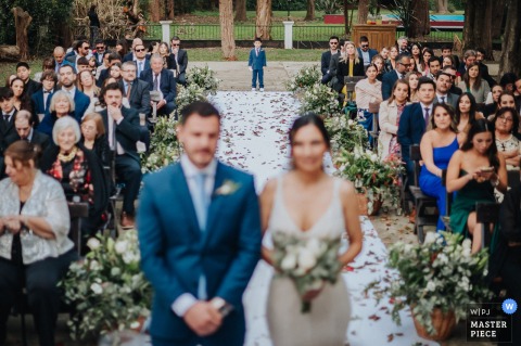 At the chapel in Haras Santa Lucia, Buenos Aires, the couple’s son waits for his cue to bring the rings forward, with the bride and groom softly blurred in the foreground.