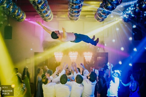 At Salon Santa Lucia Eventos in Arpilar, the groom soars skyward during the celebration, launched by guests whose acrobatic skill and daring bring an exciting, high-energy atmosphere to the party.