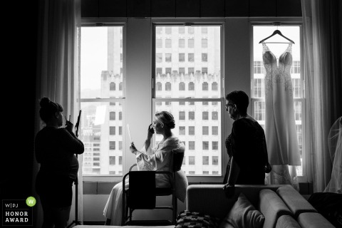 In a hotel room in Kansas City, Missouri, the bride sits patiently as her makeup is expertly done in preparation for her special day.