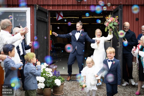 Just after their ceremony in Barsebäckshamn, Sweden at Smedjans hus, the couple and their children celebrate together, radiating happiness and unity.