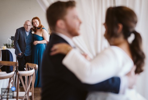 At The Fleece Countryside Inn in Ripponden, the groom’s grandfather watches as the bride and groom share their first dance, visible in soft focus in the foreground.