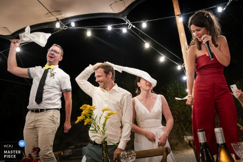 In Valence, France, guests swing napkins overhead in celebration, and the bride is accidentally struck in the face, creating a humorous and unexpected wedding moment.