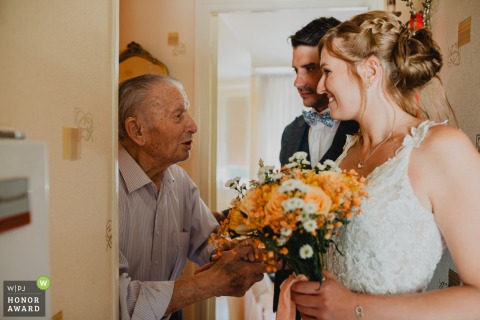 Newlyweds Share A Surprise Visit With Their Grandfather At His Home In Meuse Grand Est France At the groom’s grandfather’s home in Meuse, Grand Est, the newlyweds share a special visit with him, bringing joy and surprise since he was unable to attend the wedding.
