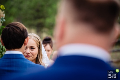During a ceremony in Helena, Montana, the bride is visibly moved as she listens deeply to her vows, her feelings clear in her expression.
