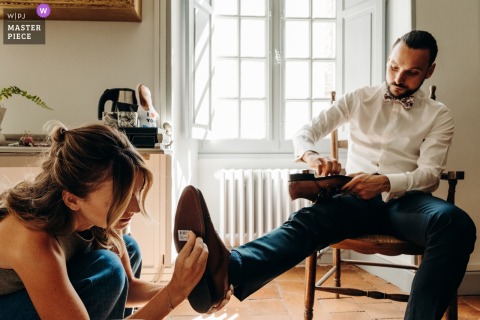 At Château de Bouge le Château in Indre, the groom forgets to remove the price tags from the soles of his shoes, adding a humorous detail to his wedding day ensemble.
