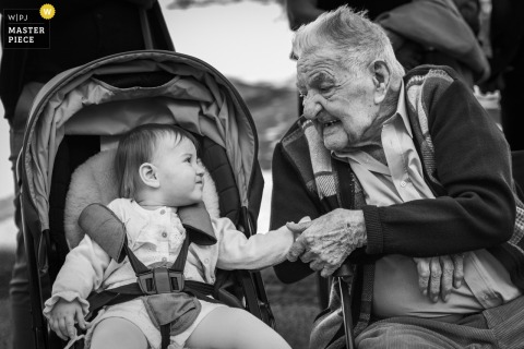 At the town hall in Clermont-Ferrand, a grandfather and his granddaughter, 93 years apart in age, sit side by side and hold hands during the wedding ceremony.