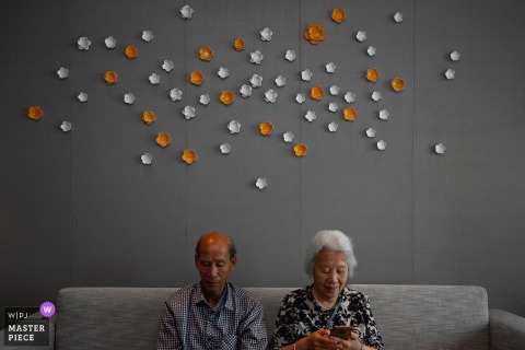 At home in Nanping, Fujian, the grandparents’ heads match the color of the wall decorations, with minimalist and symmetrical framing lending harmony and quiet beauty to the scene.