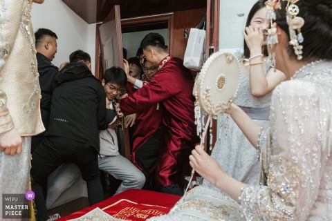 At home in Shandong, the wedding’s gate crashing game gets wild as the door is burst open, filling the moment with laughter and chaos.