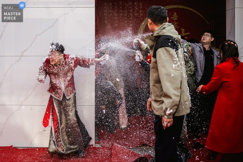 At home in Binzhou, Shandong, the groom playfully shields his face and runs away as friends pull a mischievous prank during wedding festivities.