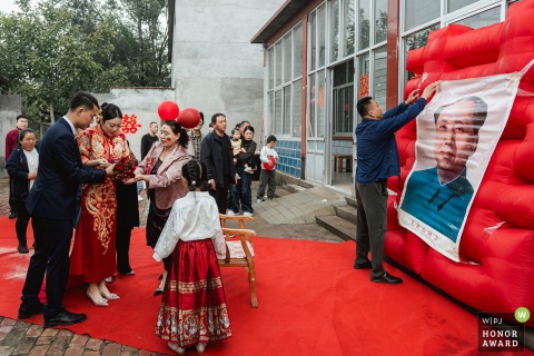 Cultural Traditions Are Observed With A Statue In Binzhou Shandong During A Local Chinese Wedding Ceremony In Binzhou, Shandong, local wedding traditions are observed as a statue of Chairman Mao is revered for protection during the couple’s transition, highlighting unique cultural customs.