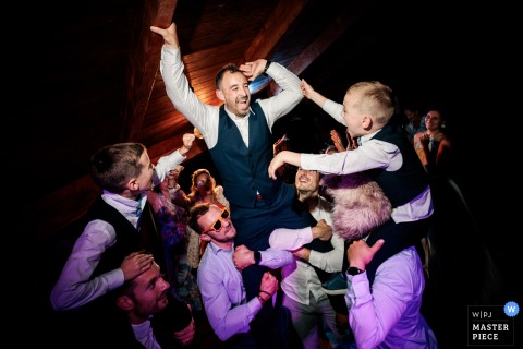 At a reception venue in Versailles, Yvelines, the groom parties with his groomsmen amid a wild celebration, capturing the lively energy and joyful family moments that make the wedding truly unforgettable.