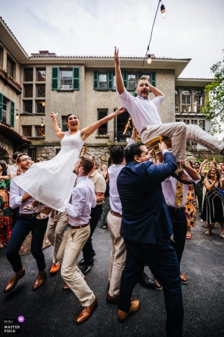 At Arrow Park, NY, the couple celebrates during the hora, lifted in chairs and beaming with joy, captured in perfect asymmetry that highlights the energetic spirit of this lively wedding tradition.