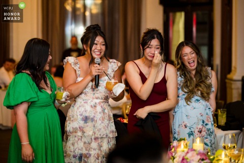 During the reception at Brasserie 701 in Montreal, Quebec, the bride’s sisters toast the couple, each displaying a unique reaction, speaking, sobbing, grinning, and observing.