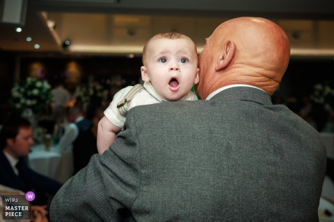 At The Vu on Ballencrieff Reservoir, West Lothian, a baby’s wide-eyed expression steals the spotlight during the reception, capturing a delightful and candid moment of curiosity amid the celebrations.