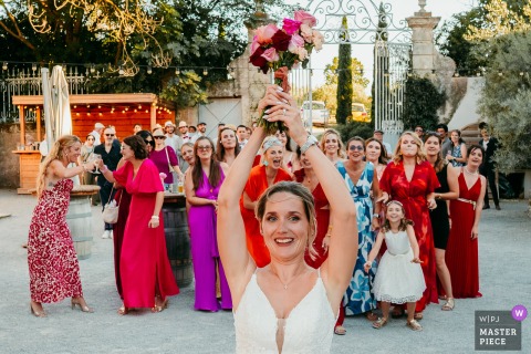 At Domaine de la Grangette in Montagnac, guests eagerly gather for the bouquet toss, capturing a lively and anticipated wedding tradition full of excitement and energy.