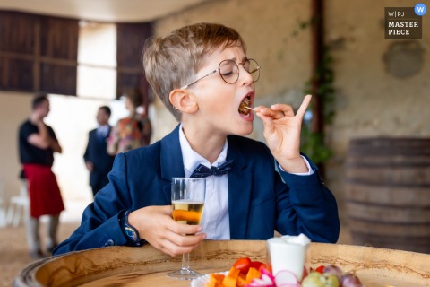 At Château de Cypierre, the newlyweds’ nephew enjoys hors d’oeuvres on his own, capturing a candid and charming moment of youthful delight amid the elegance of the celebration.