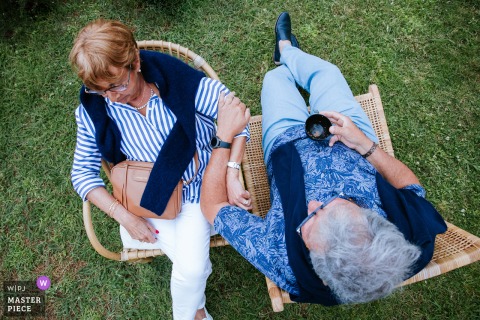 At Villa Clara in Anglet, a high-angle shot captures two elderly guests seated on the grass in chairs during cocktail hour. Arranged in a yin-yang style, the image beautifully reflects balance, companionship, and quiet elegance.