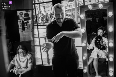 At the Koc Museum in Istanbul, Turkiye, a black-and-white shot captures a preparation moment with the bride reflected in the mirror, joined by the groom, her grandmother, and sister. The image beautifully blends family connection and anticipation.